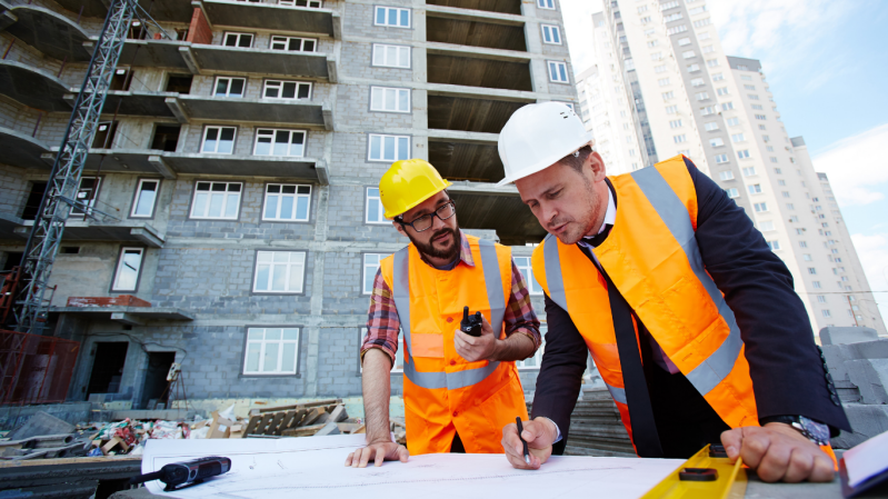 Deux professionnels sur un chantier échangeant sur l’organisation et le suivi des travaux