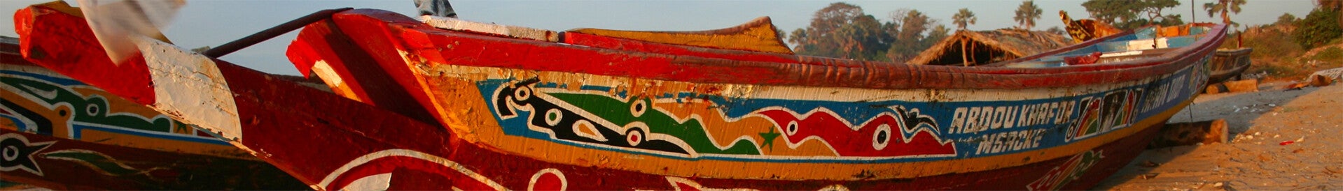 Colourfully painted fishing boat near Gunjur, The Gambia