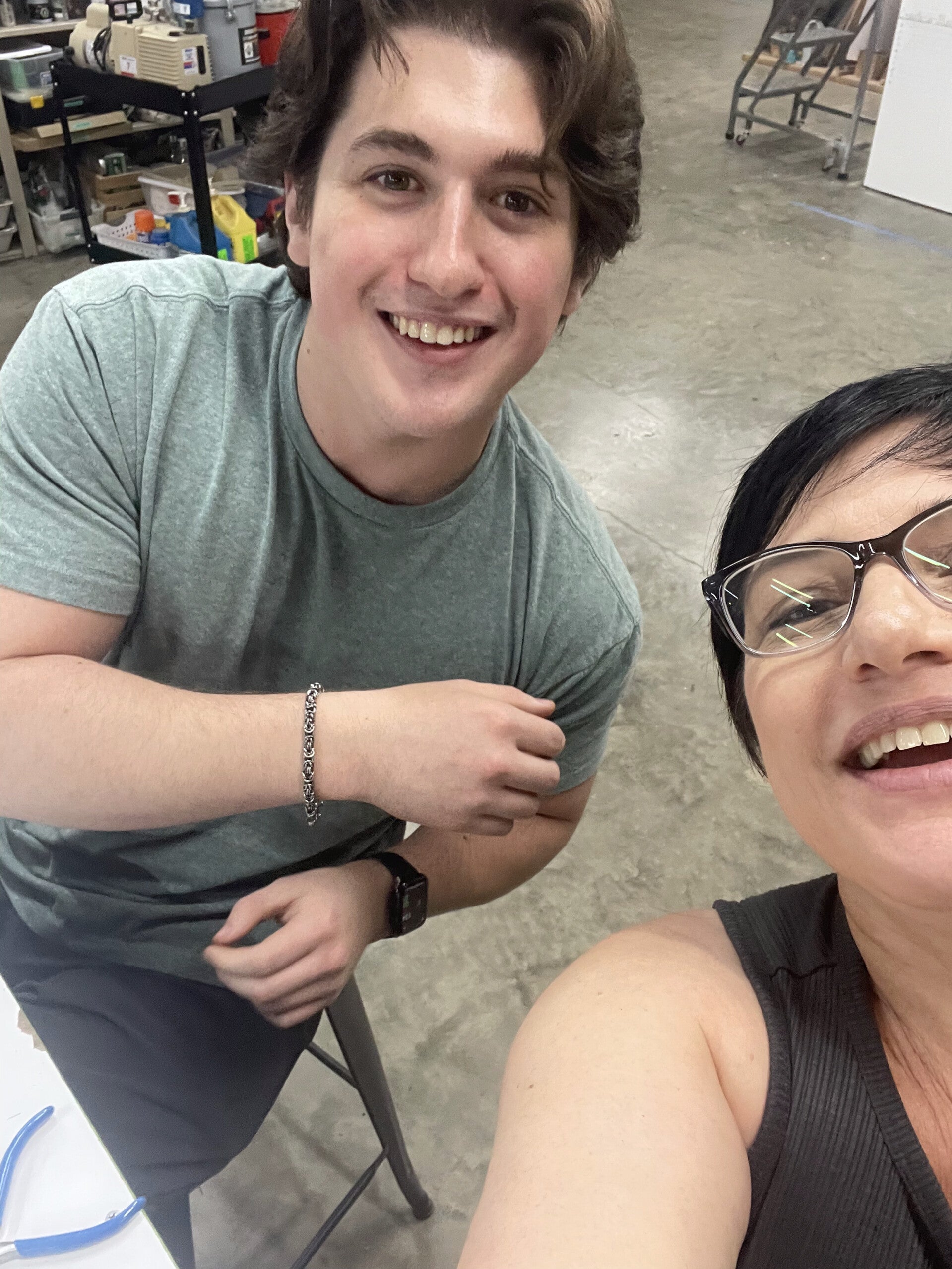 Laurie smiling with her son Harry in a workshop space.