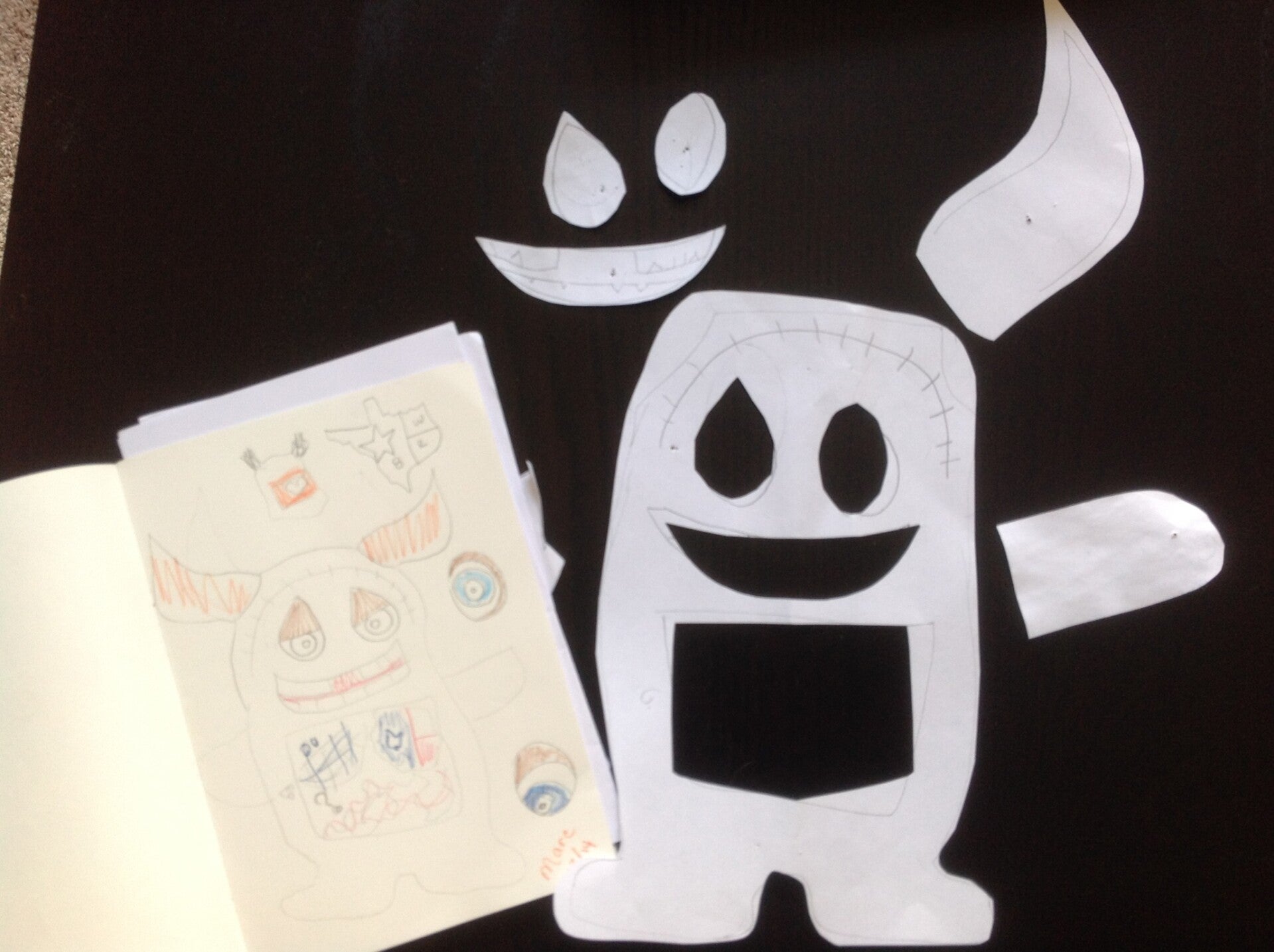 A handmade monster drawing displayed alongside a black-and-white monster illustration.