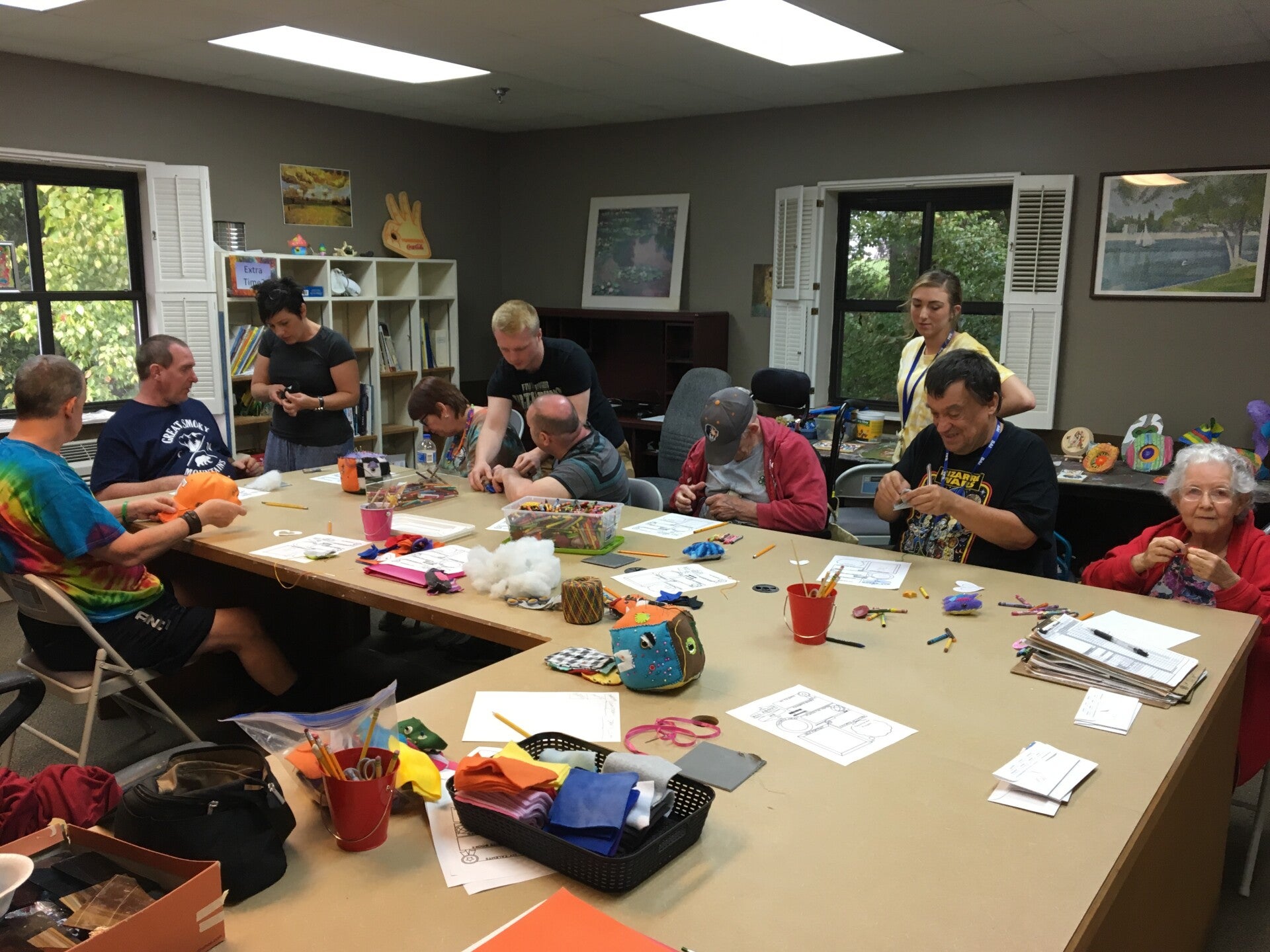 People of all ages enjoying a Monsters Made with Love nonprofit sewing workshop.