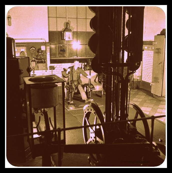 Een machinist bedient het mechanisme voor liften.Voor hem staat een groep verkeerslichten die laat zien op welk niveau de liftkooien zijn Zowel personeel als kolen worden zo vervoerd 1945 Stm.Emma.© www.gluckauf.nl