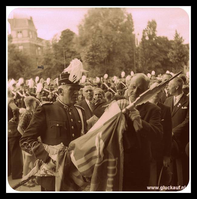 De vaandel dragen van de muziek korps van de Stm. Emma, krijgt een erelint aan het vaandel geknoopt. In 1953.© Buurman./www.gluckauf.nl