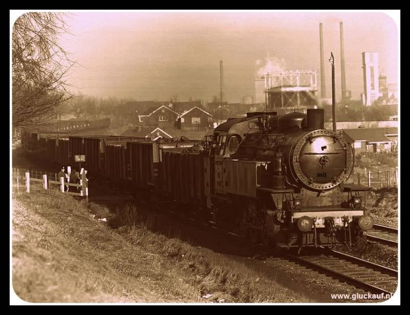 Hier een prachtige foto van een locomotief met wagons die net vertrokken is vanuit de Stm. Emma, geladen met kolen. Rechtsachter op de foto zie je de Stm. Emma met 2 schoorstenen en de bekende schacht 3. De foto is  uit de jaren vijftig. © Stm.Emma./www.g
