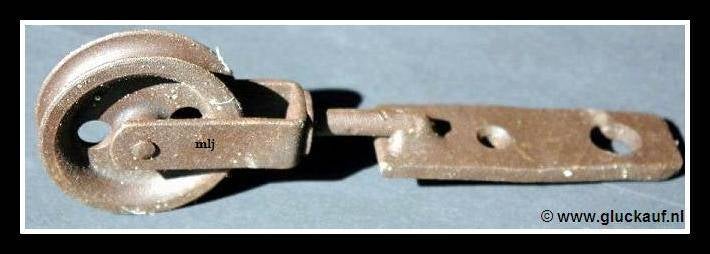 Klerenhaakgeleider, de bouten zaten vast aan het plafond en over de wieltjes liep de ketting. Ze zijn afkomstig van het voormalige badlokaal van de Staatsmijn Emma. © www.gluckauf.nl