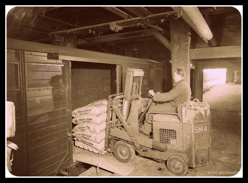 De productie zakken van de SBB worden ingeladen in de wagons. Zie op de vorkheftruck de letters staan SM ( Staatsmijn Maurits ), de foto is uit 1955.© Spies/gluckauf.