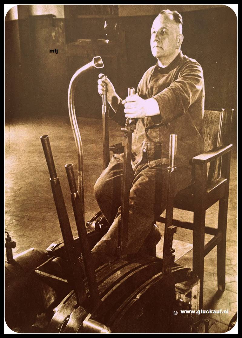 Ophaalmachinist Zeelen van de domaniale mijn. Met de linkerhand bedient hij de handle van de stoomrem , met de rechter regelt hij de stroomtoevoer van de stoommachines. Door de spreekbuis houdt hij contact met de losvloer 1947.© Cals/www.gluckauf.nl