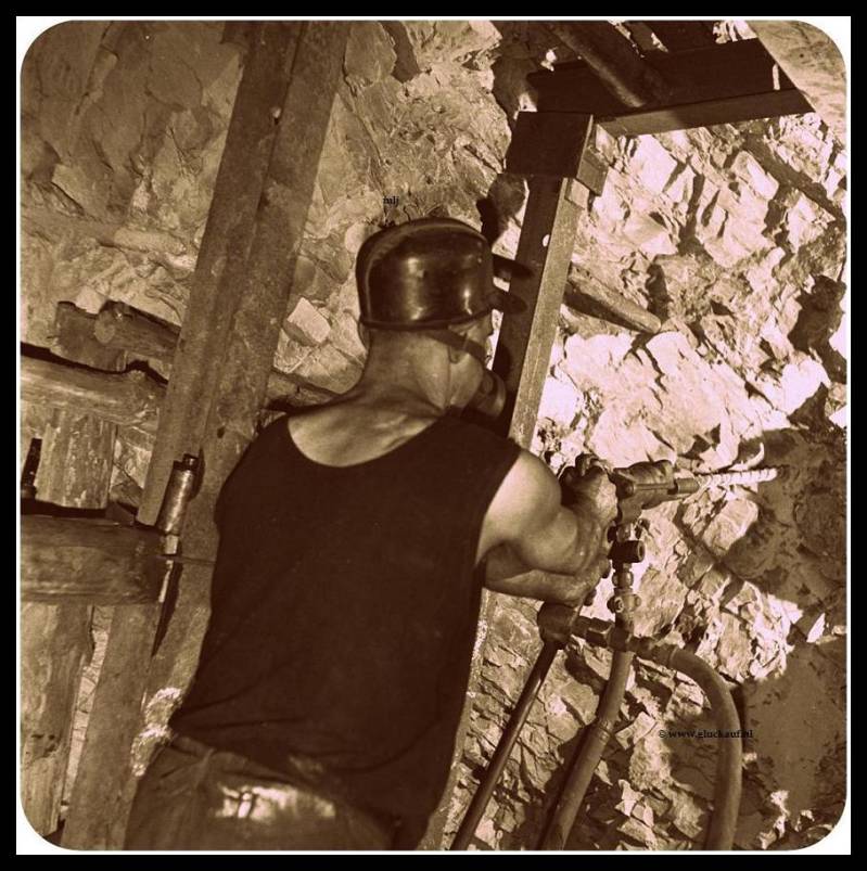 Houwer achter een boorhamer met een stofmasker op. In 21 november 1945 in de Stm. Emma.© ANEFO./www.gluckauf.nl