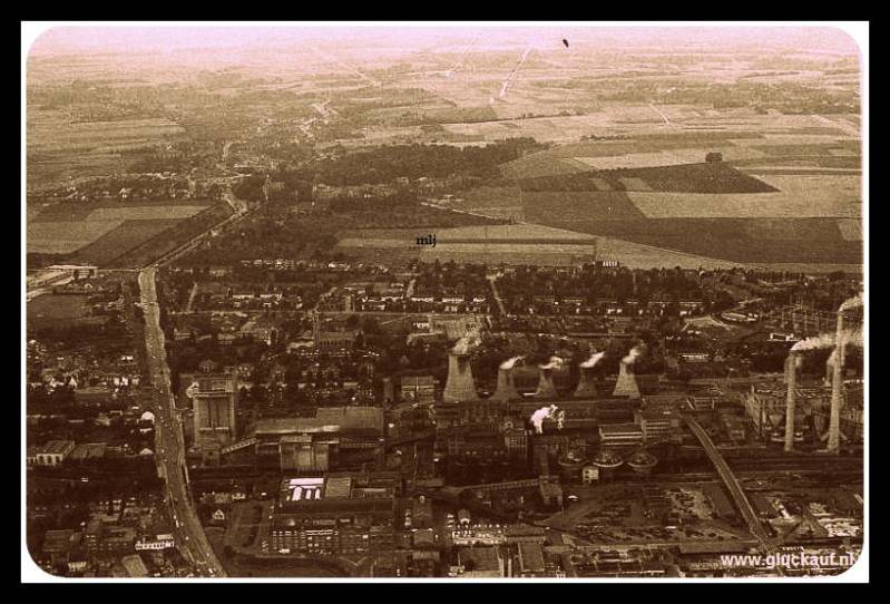 24 augustus 1965, is deze foto genomen van de Stm. Emma. De foto is genomen vanaf de rechterzijde van de mijn, de grote weg aan de linkerkant is de Akerstraat met daar pal naast Schacht 3. © Bos./www.gluckauf.nl