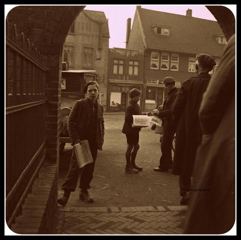 Kranten jongens verkopen de krant aan mijnwerkers van de Staatsmijn Emma, bij het verlaten van de Mijn in 1945. © www.gluckauf.nl