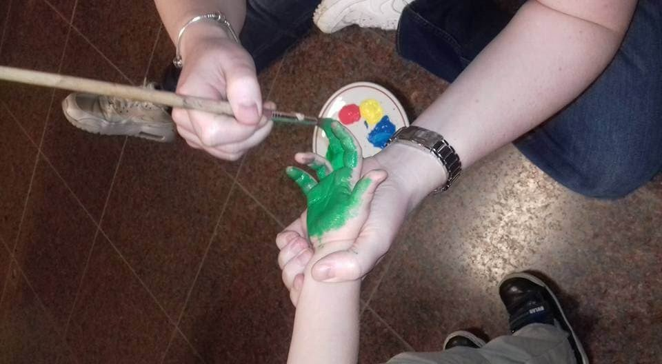 Een kinderhand word geverft in het groen