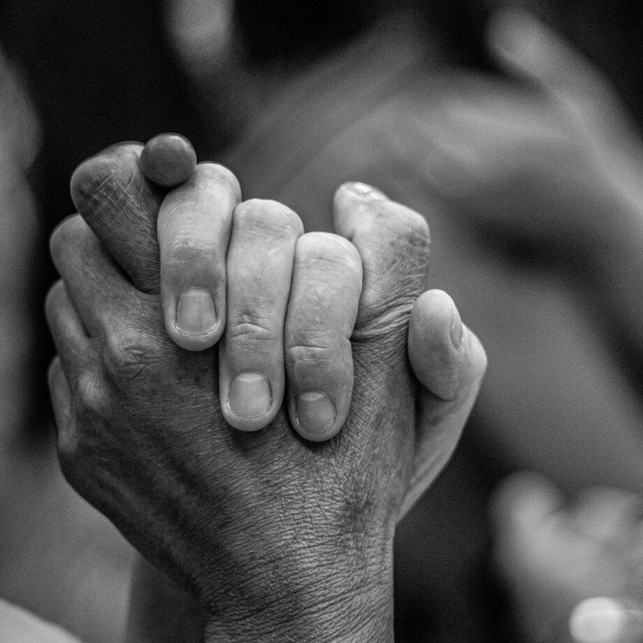 Twee handen die elkaar stevig vasthouden.