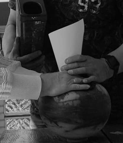 vier handen op een urn