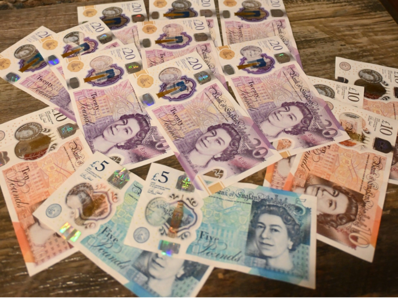 Scattered British pound banknotes in various denominations