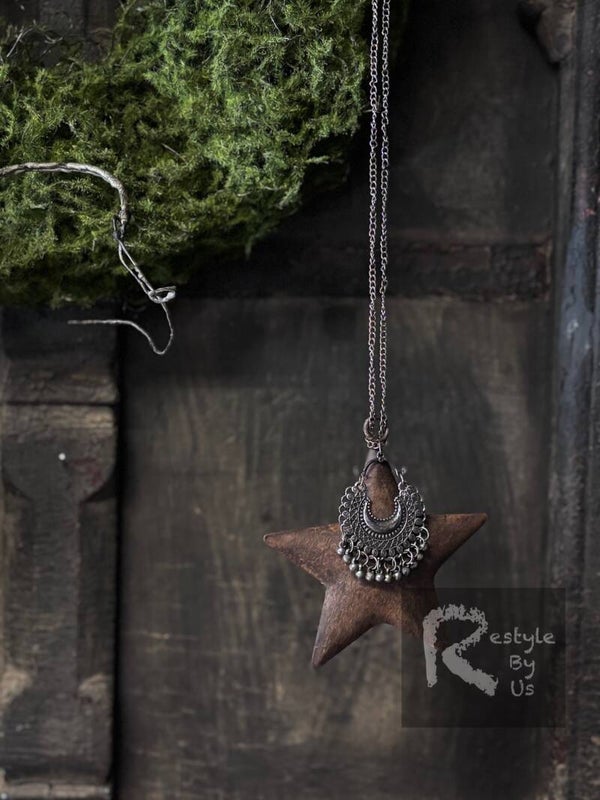 Roestige metalen ster met sieraad