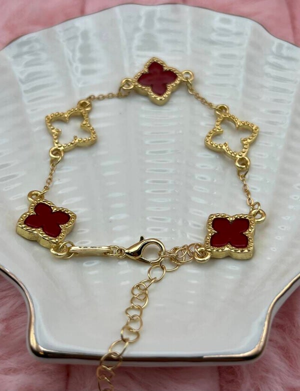 Goudkleurige armband met open en rode klavertjes