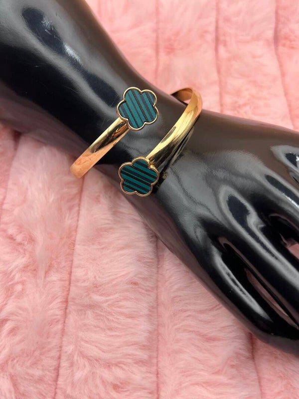 Goudkleurige bangle armband met groene bloemklavers