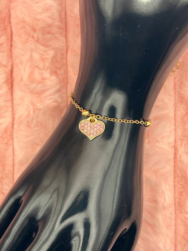 Goudkleurige armband met roze glitterhartje