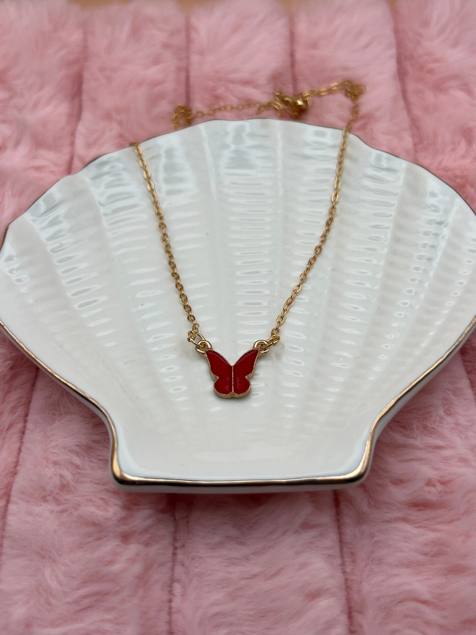 Goudkleurige ketting met rode vlinder