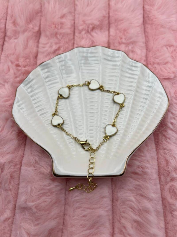 Goudkleurige armband met witte hartjes