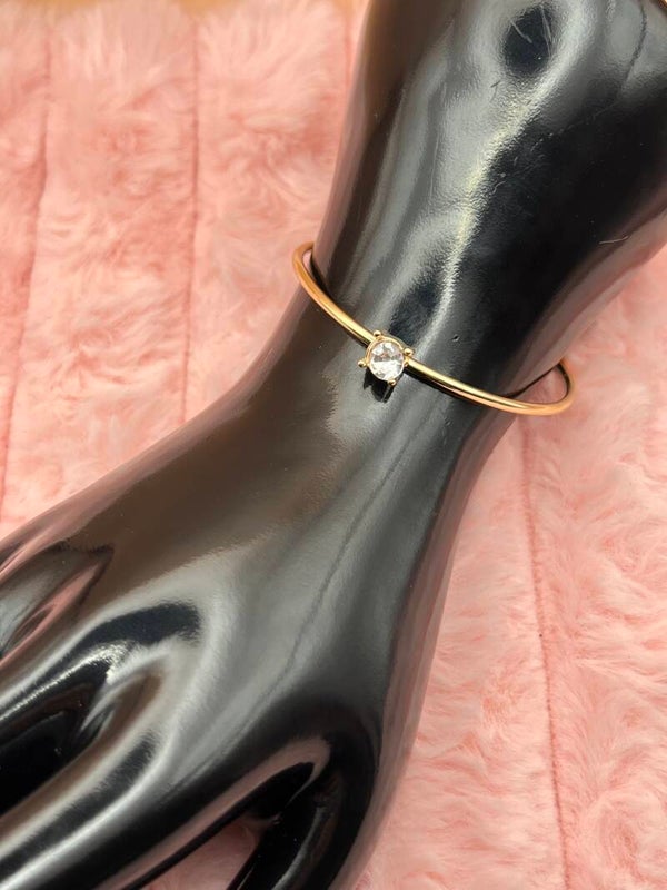 Goudkleurige bangle armband met fonkelende steen