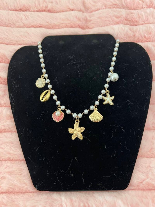 Goudkleurige ketting met parels en zeebedels
