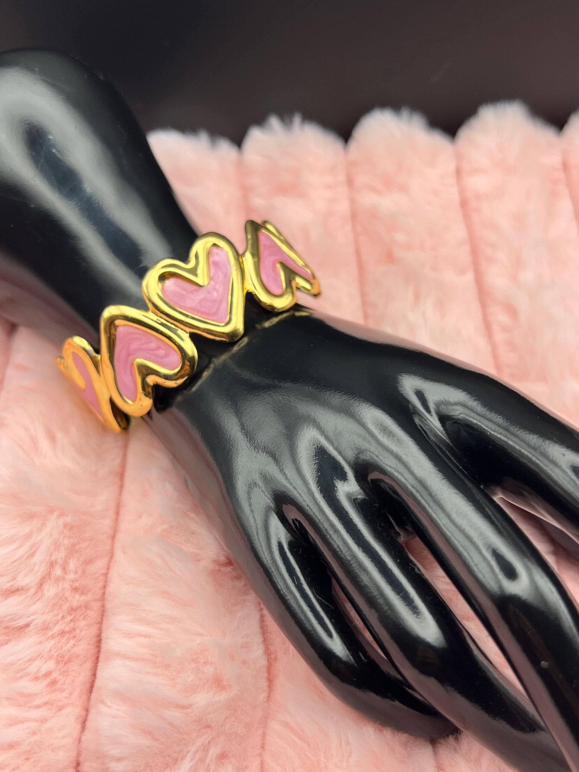 Goudkleurige bangle armband met roze hartjes