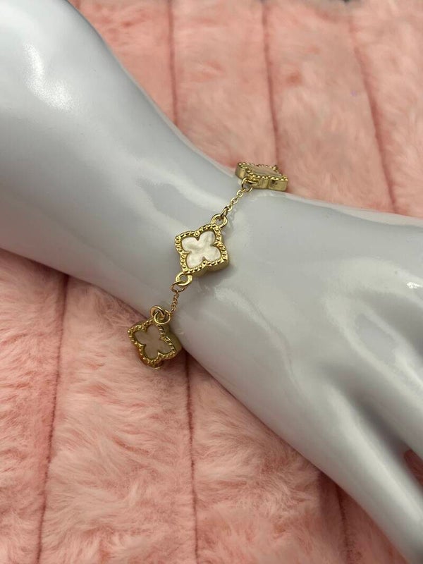 Goudkleurige armband met witte klavertjes