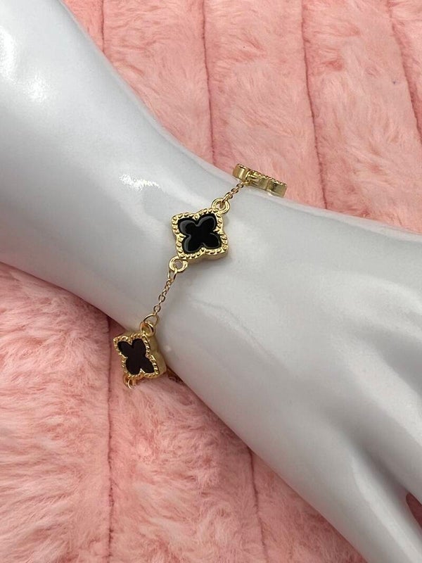 Goudkleurige armband met zwarte klavertjes