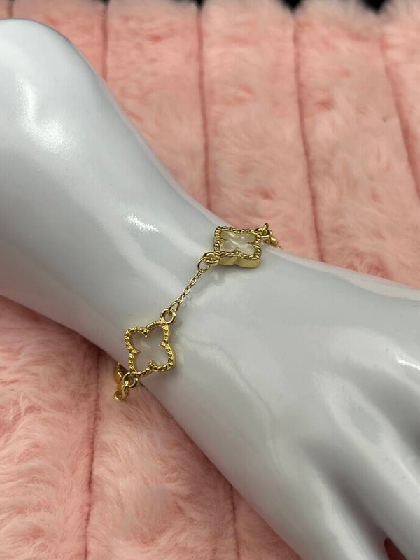 Goudkleurige armband met open en witte klavertjes