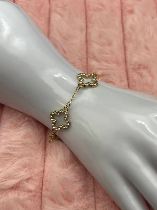 Goudkleurige armband met bloemklavers en strass steentjes