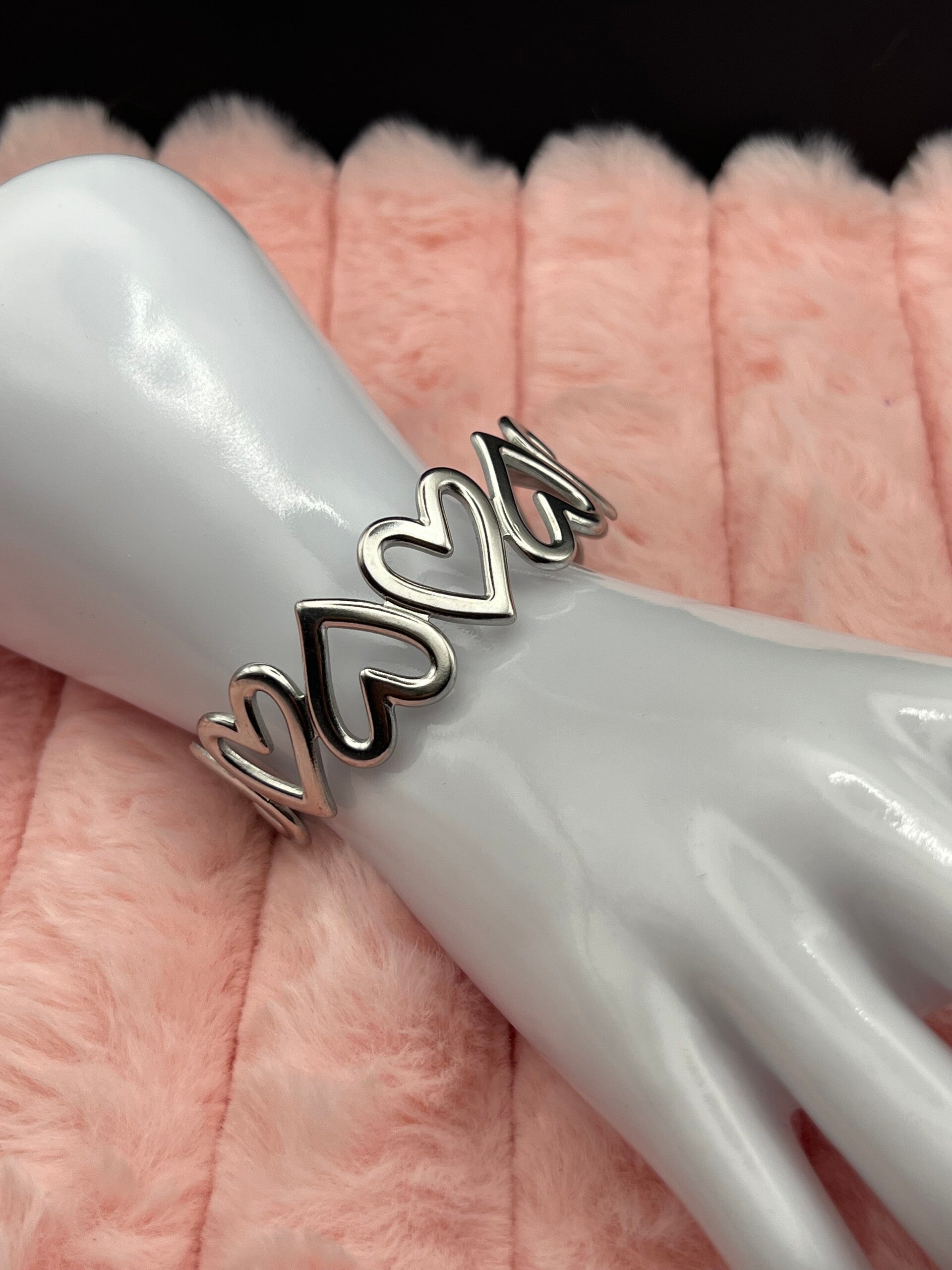 Zilverkleurige bangle armband met open hartjes