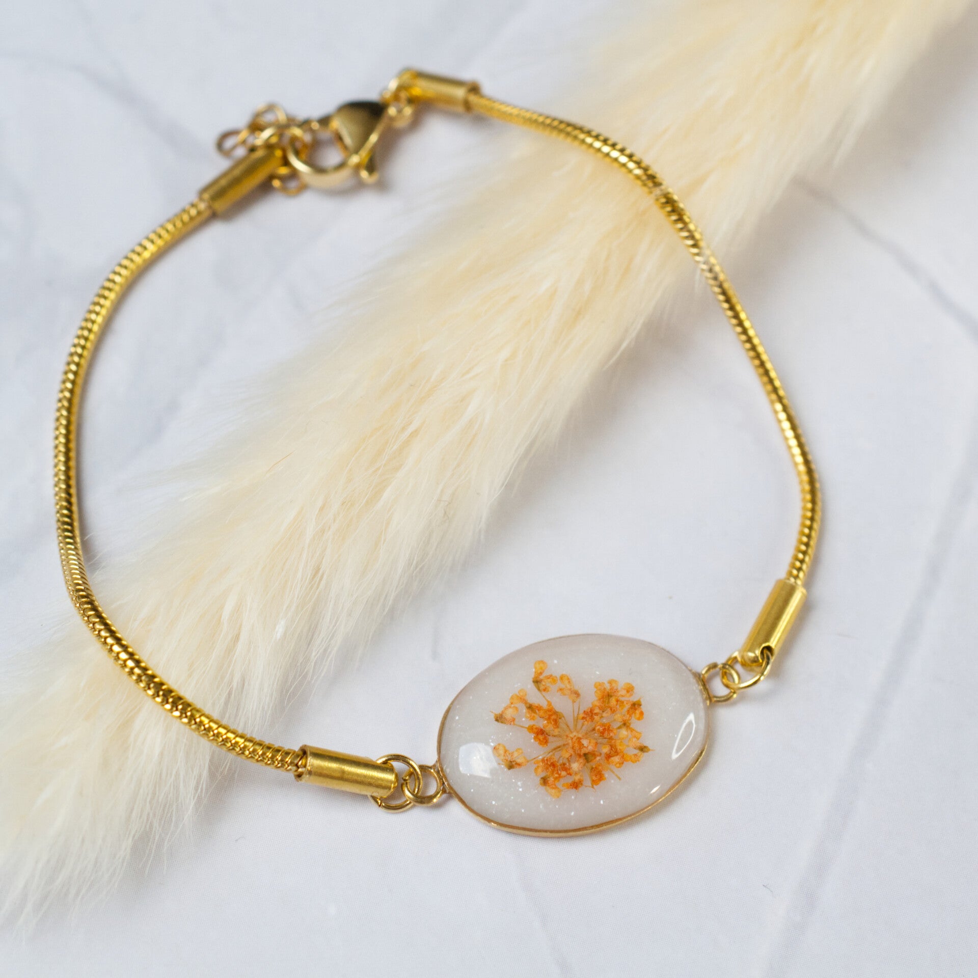 Gouden rvs armband met ovale bedel en droogbloem