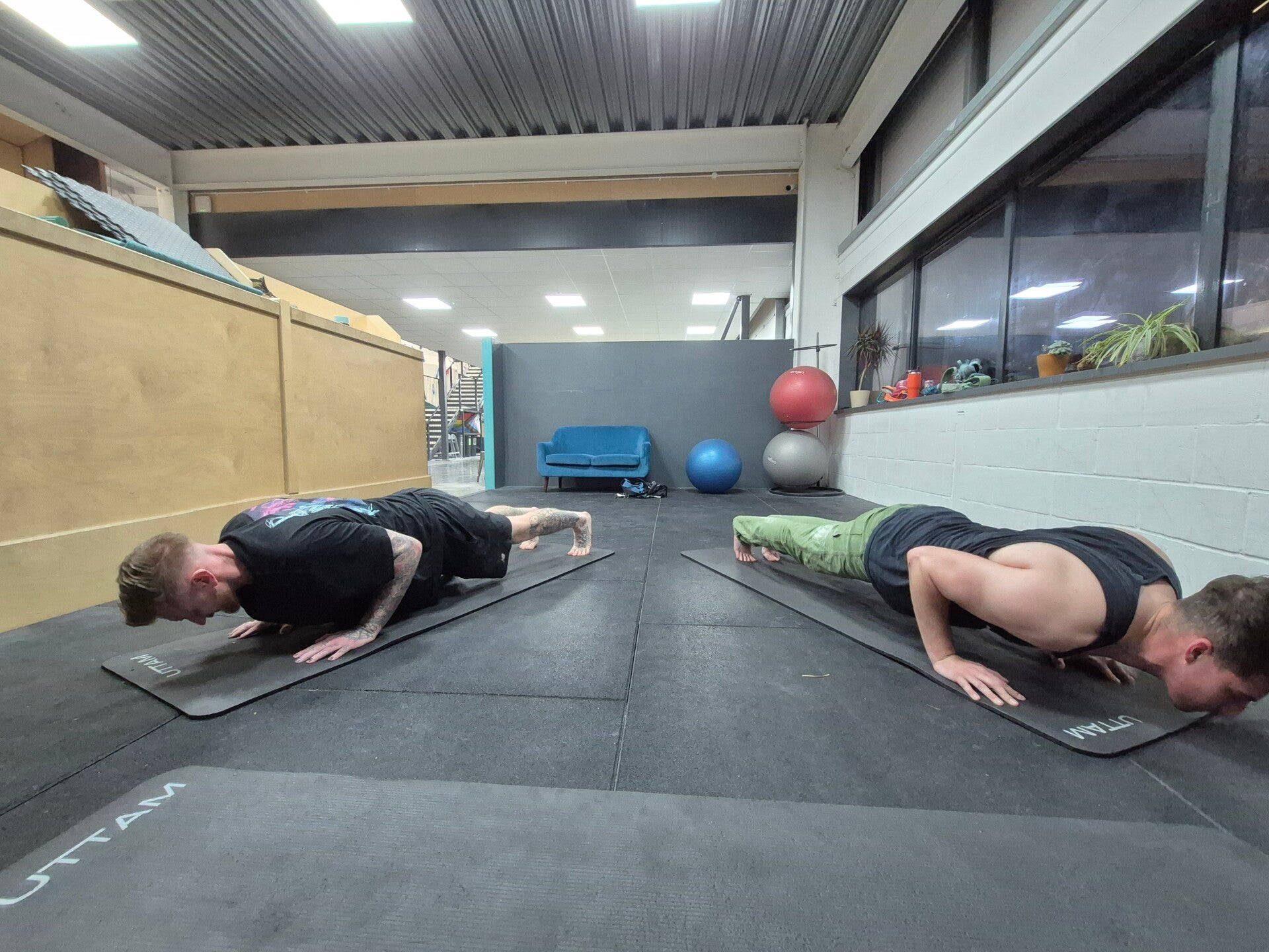 Two men in plank position practicing yoga