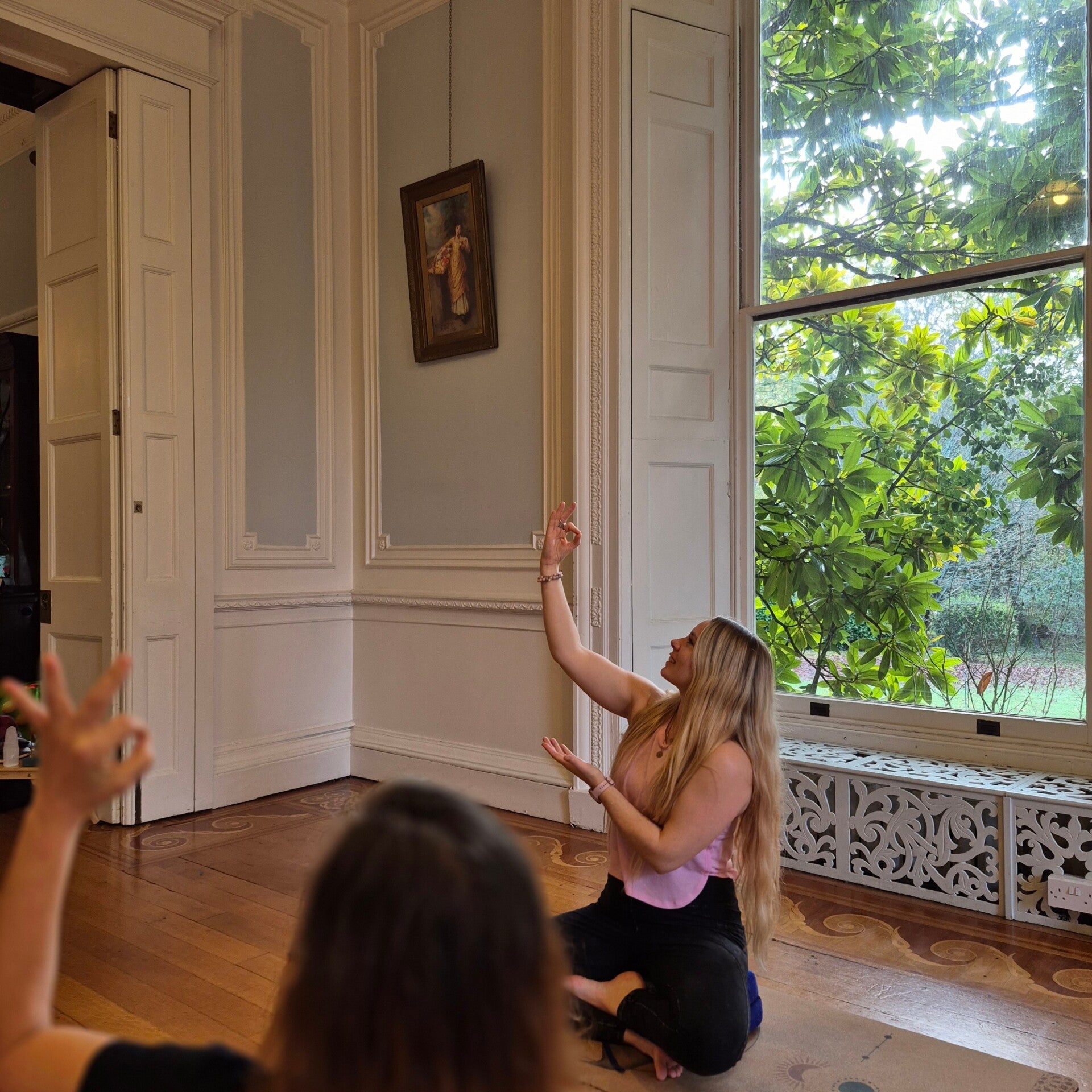 Picture of a woman teaching a yogic hand gesture known as a mudra