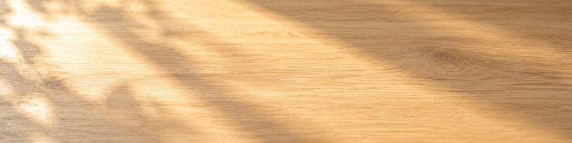 Table en bois clair traversée par une lumière dorée