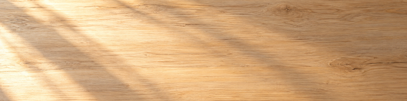 Table en bois clair traversée par une lumière dorée