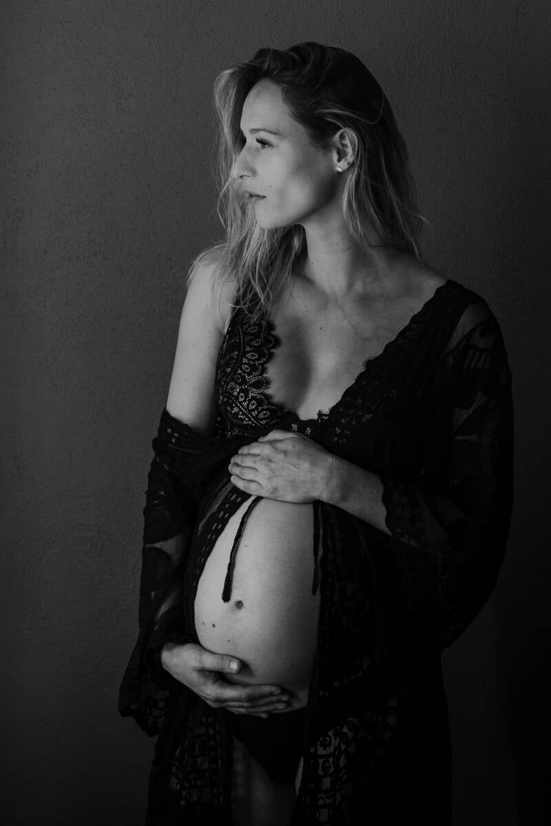 zwangere vrouw in kaftan en zwarte lingerie