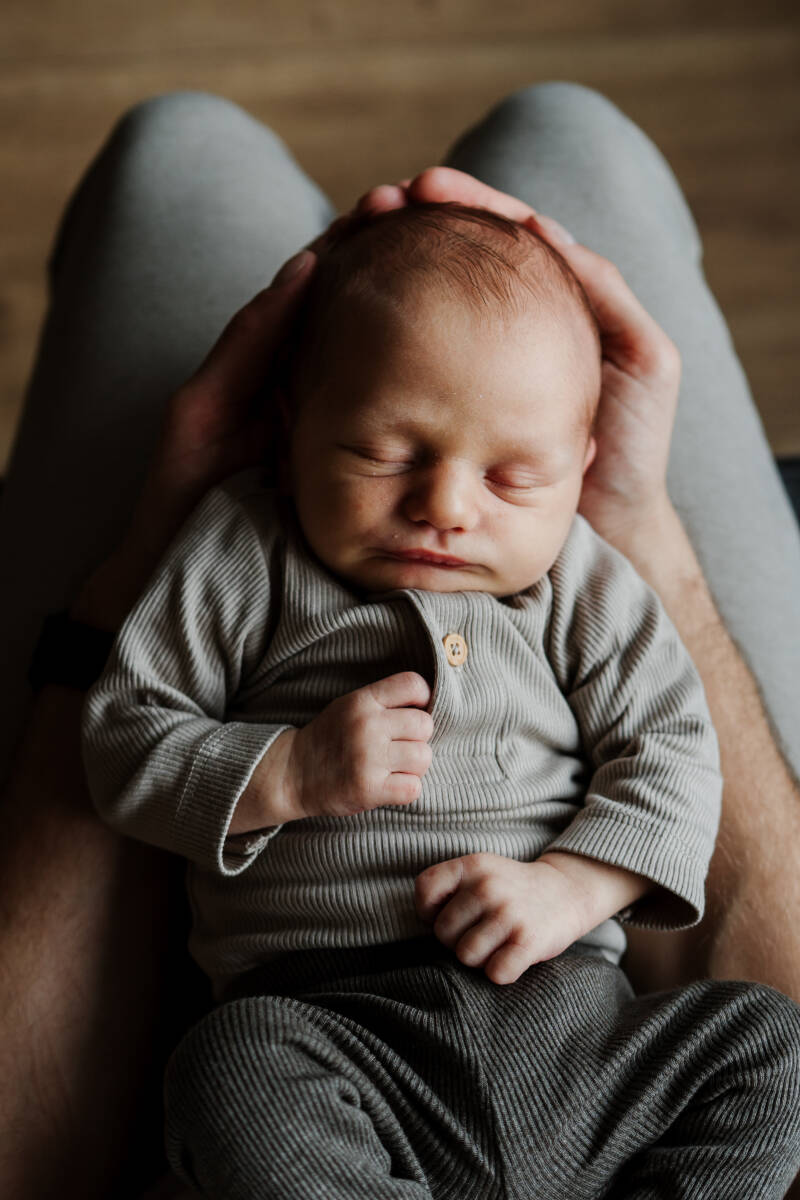 baby van bovenaf gefotografeerd slapend op schoot 