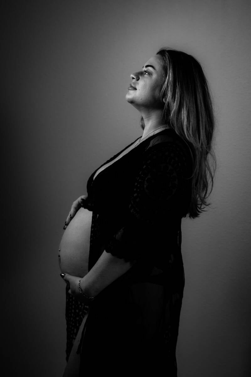 krachtige zwangere vrouw strak voor zich uitkijkend met neus iets in de lucht