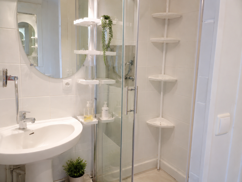 Salle d'eau fonctionnelle avec douche, lavabo et rangements pratiques.