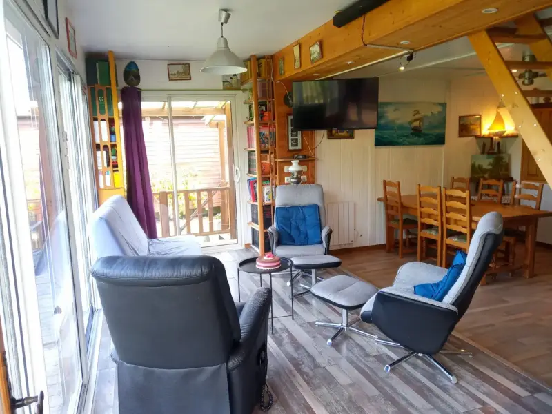 Pièce à vivre d’un gîte en Sologne avec salon confortable, espace repas et accès terrasse à Nouan-le-Fuzelier proche Lamotte-Beuvron