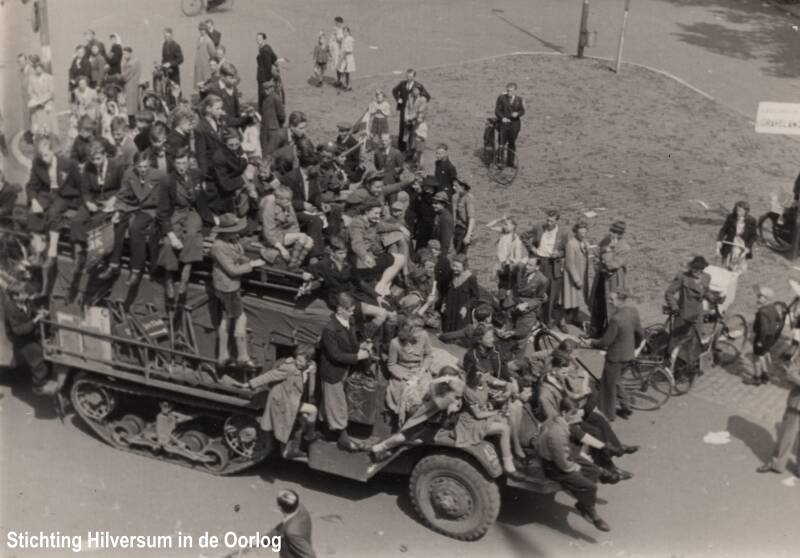 Hilversumse burgers op een Engels legervoertuig van de 49th West Riding Division (Polar Bears). Foto Hugo van der Valk. Collectie Hilversum in de Oorlog.