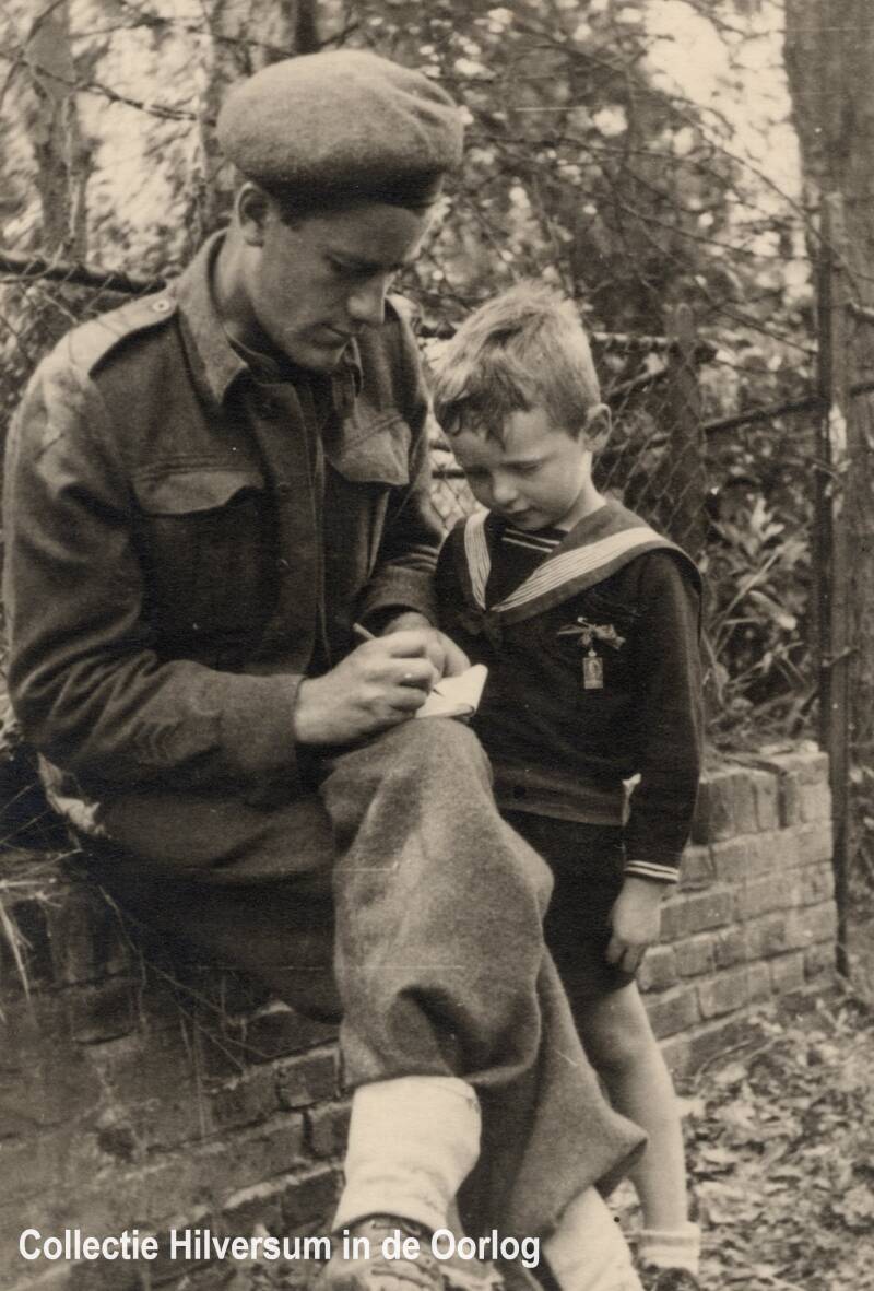 Geallieerde militair geeft handtekening aan kind, foto A. Groenink-Cuperus. Collectie Hilversum in de Oorlog.