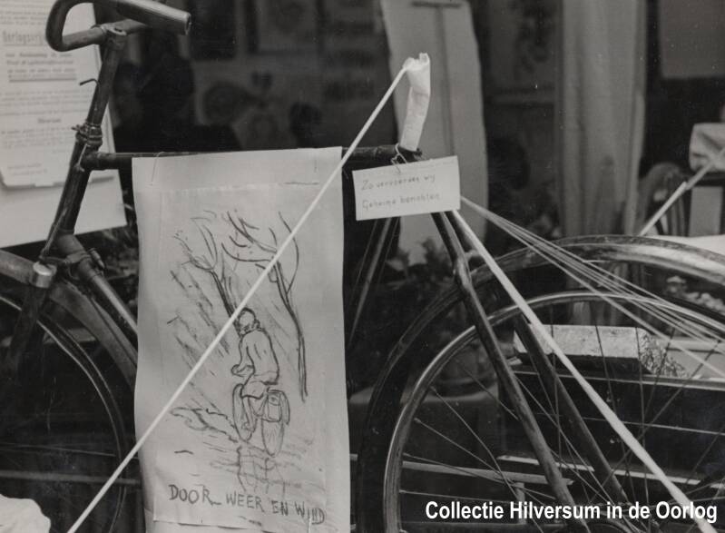 Een fiets van een koerierster, tentoongesteld op de tentoonstelling. Onder het zadel werden geheime berichten vervoerd. Collectie Hilversum in de Oorlog