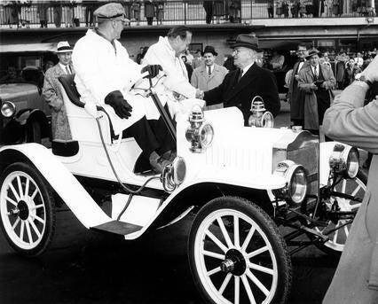 El comediante Jack Benny (mostrado aquí estrechando la mano de Harry S. Truman desde el asiento de un Maxwell Roadster de alrededor de 1908)