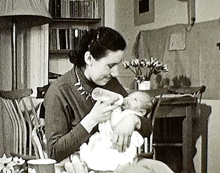 mijn moeder die mijn zusje de fles geeft op 8mm film