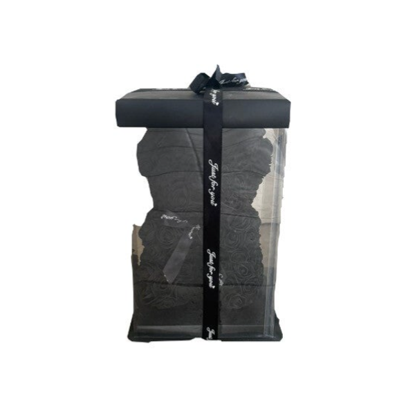 Black teddy bear in the box.