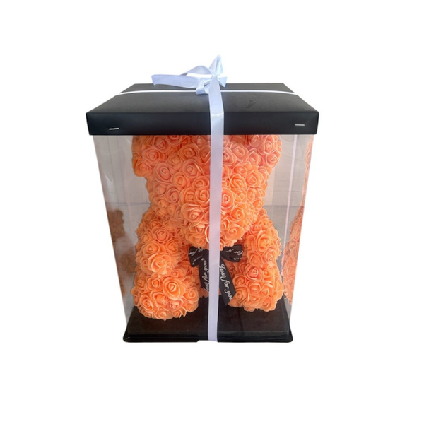 Orange teddy bear in the box.