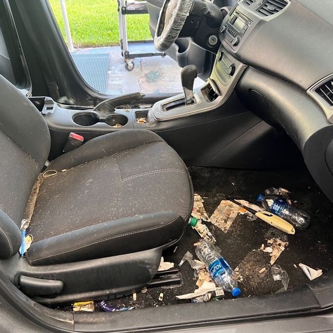 Nissan interior before restoration with debris and stained carpet